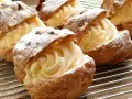 Bignè ripieni di crema pasticcera, spolverati di zucchero a velo. La farina per bignè W è perfetta per questa preparazione.