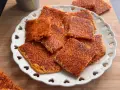 Schiacciata di riso croccante, dorata e invitante, servita su un piatto bianco decorato con cuoricini. Perfetta per uno snack goloso.