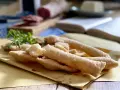 Sgabei fritti dorati e croccanti, profumati con rosmarino fresco, pronti per essere gustati con salumi e formaggio.