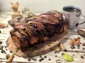 Babka ponczowa, intrecciata e ricca di gocce di cioccolato, pronta per essere gustata con una tazza di caffè.