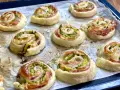 Rotolini dorati di pasta sfoglia con zucchine e scamorza filante, appena sfornati e pronti per essere gustati.