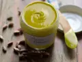 Un vasetto di cremosa crema di pistacchio, con pistacchi sparsi intorno. Perfetta per dolci e colazioni.
