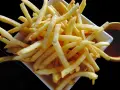 Un piatto di croccanti patatine fritte, perfette per un aperitivo, con una ciotolina di salsa rossa. Un classico intramontabile, come i veri frytki po włosku.