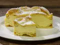Fetta di Karpatka, dolce polacco con crema pasticcera e pasta choux, spolverata di zucchero a velo. Un delizioso karpatka przepis.