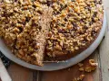 Torta noci e amaretti, soffice e golosa, ricoperta di noci tritate e gocce di cioccolato.
