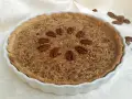 Torta di noci croccante e dorata, decorata con noci intere disposte a cerchio. Un delizioso pandi noci pronto da gustare.