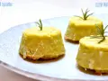 Flan di topinambur senza patate, dorati e profumati, guarniti con rosmarino fresco su un piatto bianco decorato.