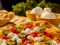 Pinsa crudo e burrata con verdure grigliate: zucchine, peperoni rossi e gialli, e soffice burrata su una base croccante.