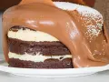 Torta al cioccolato a strati con glassa al cioccolato fusa che cola, decorata con perline bianche. Un vero tsunami di dolcezza!