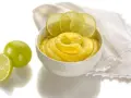 Una ciotola di cremosa crema al lime, guarnita con fette di lime fresco e accompagnata da lime interi e a metà.