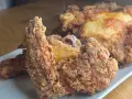 Pollo fritto croccante, un chrusty przepis che fa venire l'acquolina in bocca. Pezzi dorati e succulenti su un piatto bianco.