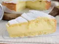 Fetta di crostata con abbondante crema allo yogurt, cosparsa di zucchero a velo.