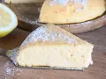 Una fetta di torta con semola, spolverata di zucchero a velo, accanto a un limone fresco.