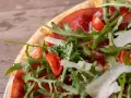 Pizza bresaola rucola e grana: un tripudio di sapori con bresaola, pomodorini, rucola fresca e scaglie di grana.