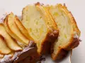Fette di plumcake ricotta e mele, con mele a vista sulla superficie e spolverata di zucchero a velo.