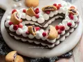 Cuore di pasta biscotto al cacao per cream tart, decorato con panna, fragoline e biscotti ripieni.