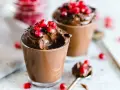 Mousse al cioccolato per profiterol, guarnita con chicchi di melagrana succosi. Un dessert goloso e invitante.
