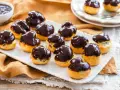 Bignè al cioccolato ricetta: deliziosi bignè ripieni e glassati al cioccolato fondente, pronti per essere gustati.