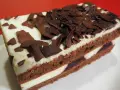 Una fetta di torta foresta nera di Montersino, con pan di Spagna al cacao, panna montata e ciliegie, decorata con riccioli di cioccolato.