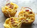 Tre tortini di pasta fritta senza glutine, dorati e croccanti, con pezzetti di pancetta.