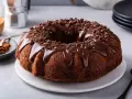 Delizioso ciambellone al cioccolato, perfetto per il tuo lukier przepis. Glassa lucida e scaglie di cioccolato per un tocco goloso.