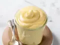 Crema chiboust ricetta originale in un vasetto, con cucchiaini d'argento accanto.