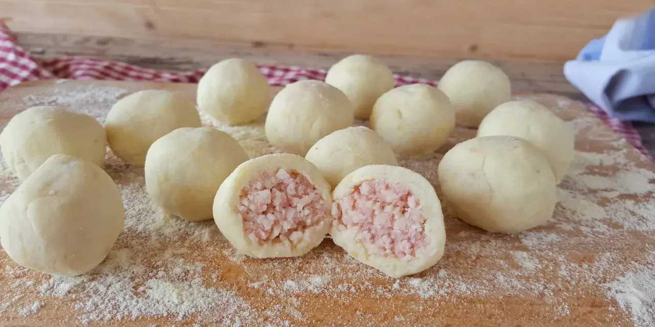 Sfere di gnocco di patate ripieno, pronte per essere cucinate. Una delizia fatta in casa.