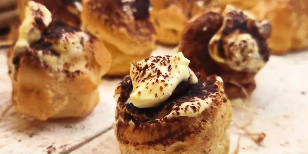 Bignè al tiramisù, deliziosi dolcetti con crema e cacao, pronti per essere gustati.