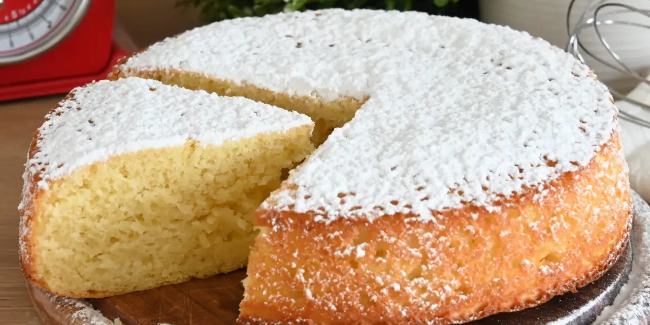 Delizioso ciasto jogurtowe, soffice e cosparso di zucchero a velo, pronto per essere gustato.