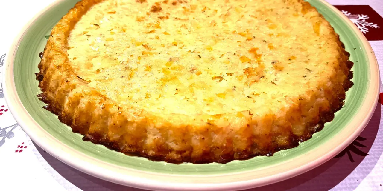 Tortino di patate con salmone e mozzarella, dorato e invitante, pronto per essere gustato.