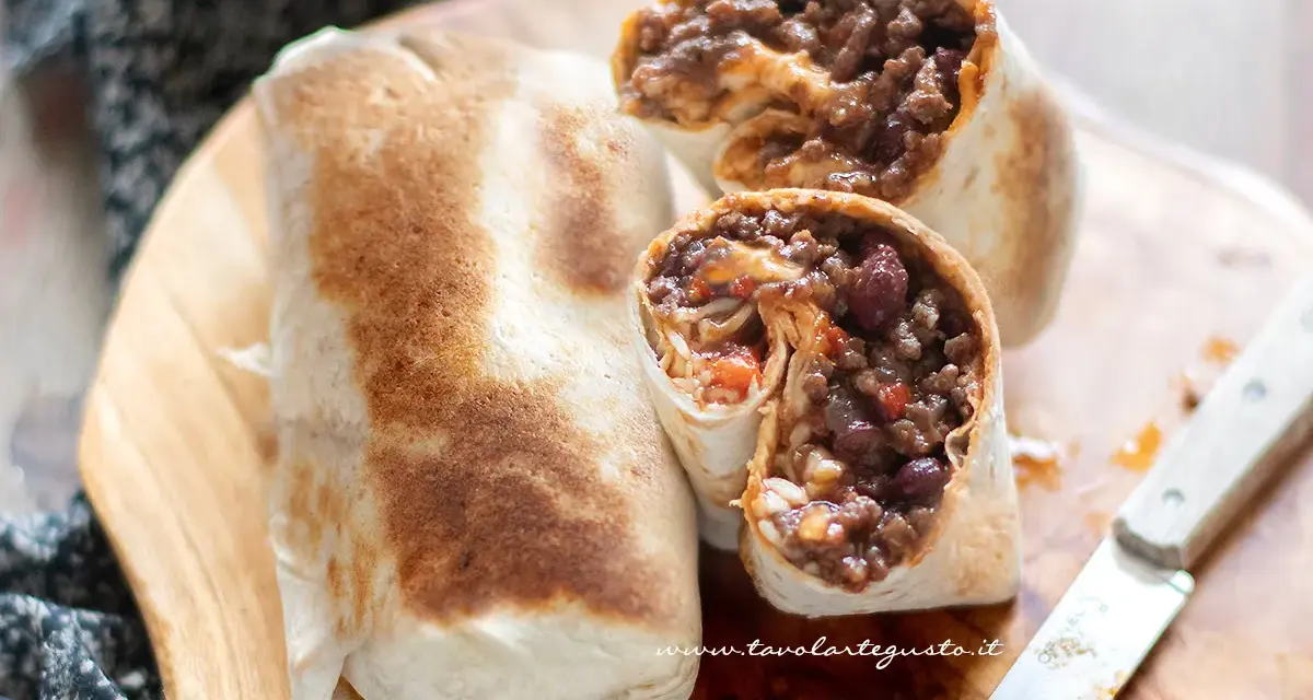 Burrito chili con carne ripieno di carne macinata, fagioli rossi e riso, pronto per essere gustato.
