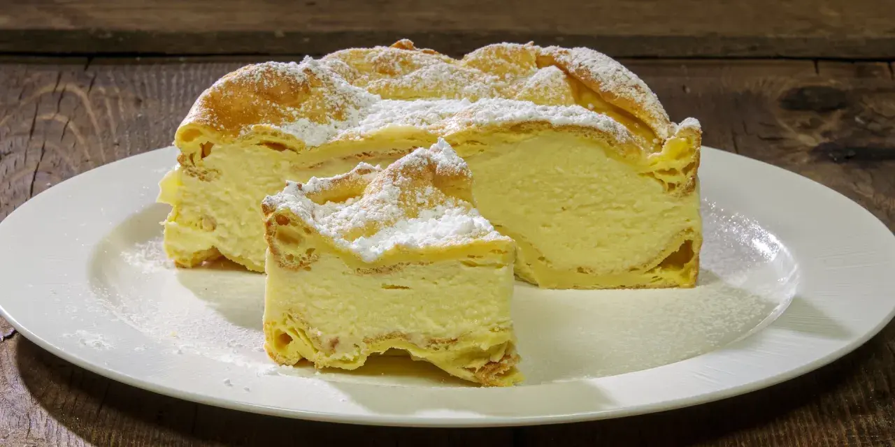Fetta di Karpatka, dolce polacco con crema pasticcera e pasta choux, spolverata di zucchero a velo. Un delizioso karpatka przepis.