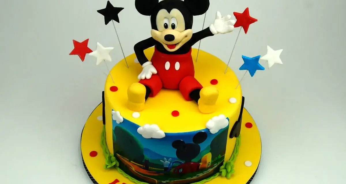 Un allegro tort Mickey Mouse con stelle colorate e una scena del cartone animato sul lato. Leone festeggia 6 anni!