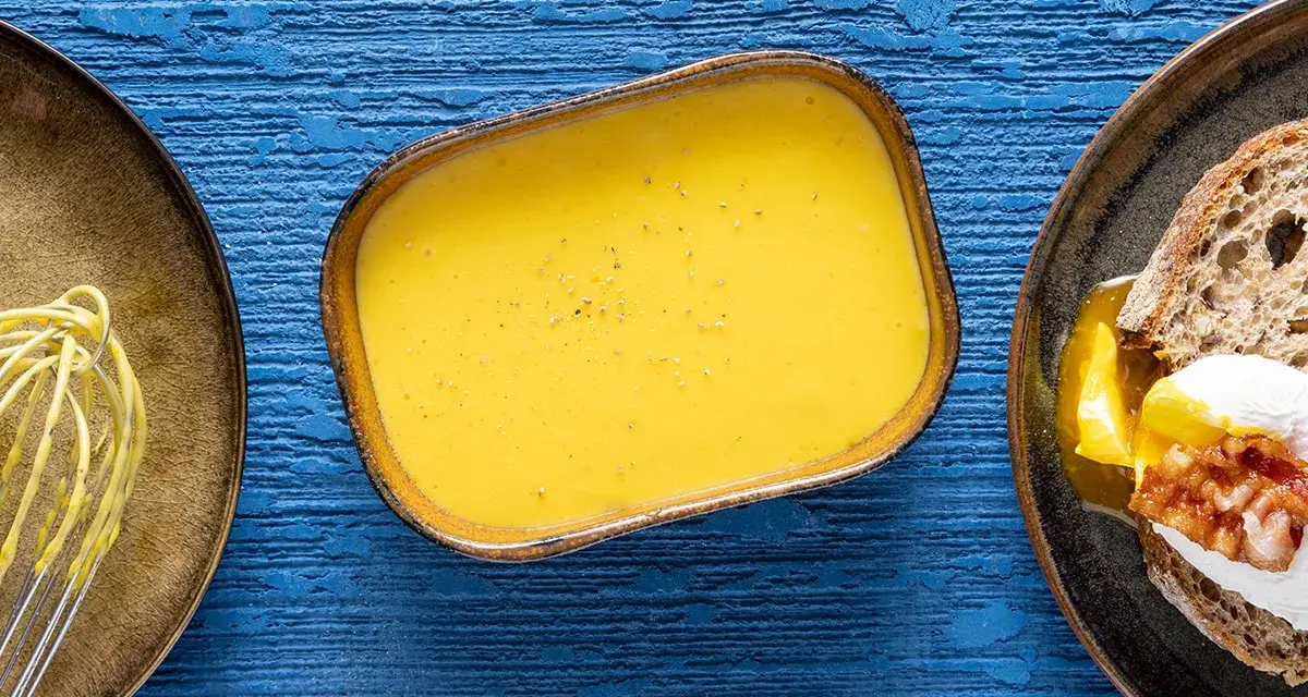 Salsa olandese, perfetta per la tua sfoglia olandese ricetta. Accanto, un uovo in camicia su pane tostato.