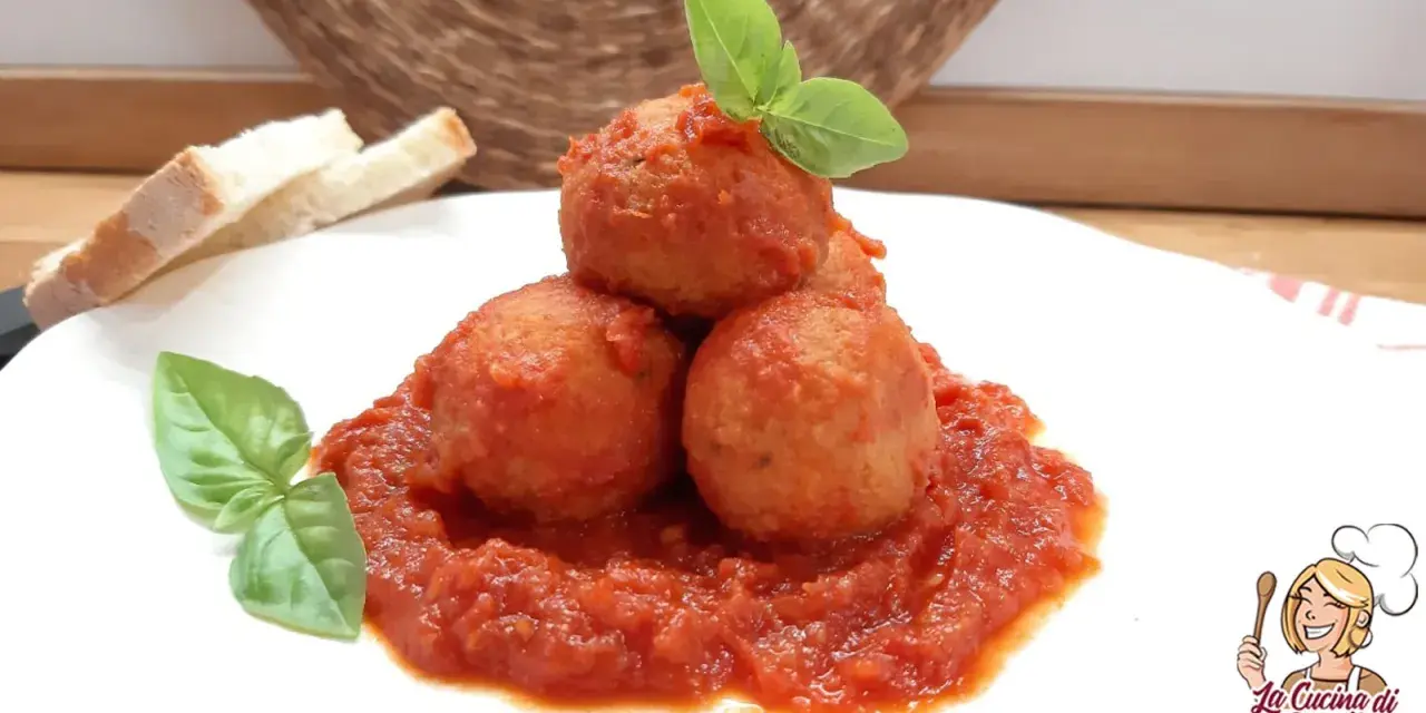 Polpette di pane in umido, un piatto confortante con pomodoro e basilico, accompagnato da fette di pane.