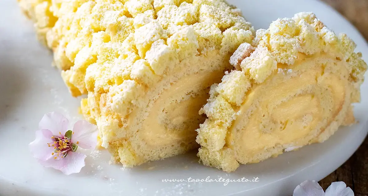 Tronchetto mimosa soffice e cremoso, decorato con briciole di pan di Spagna e fiori rosa.
