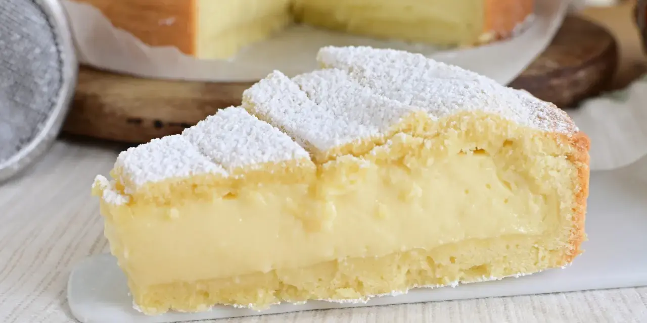 Fetta di crostata con abbondante crema allo yogurt, cosparsa di zucchero a velo.
