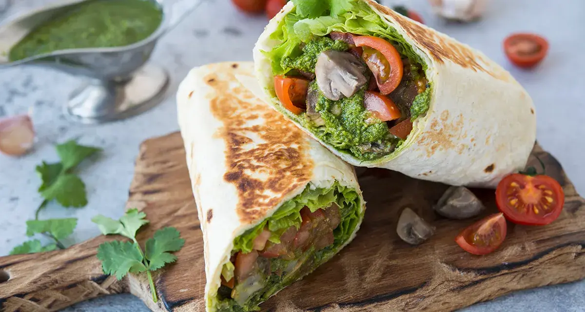 Piadina con pesto, pomodoro e lattuga, un pasto fresco e saporito.