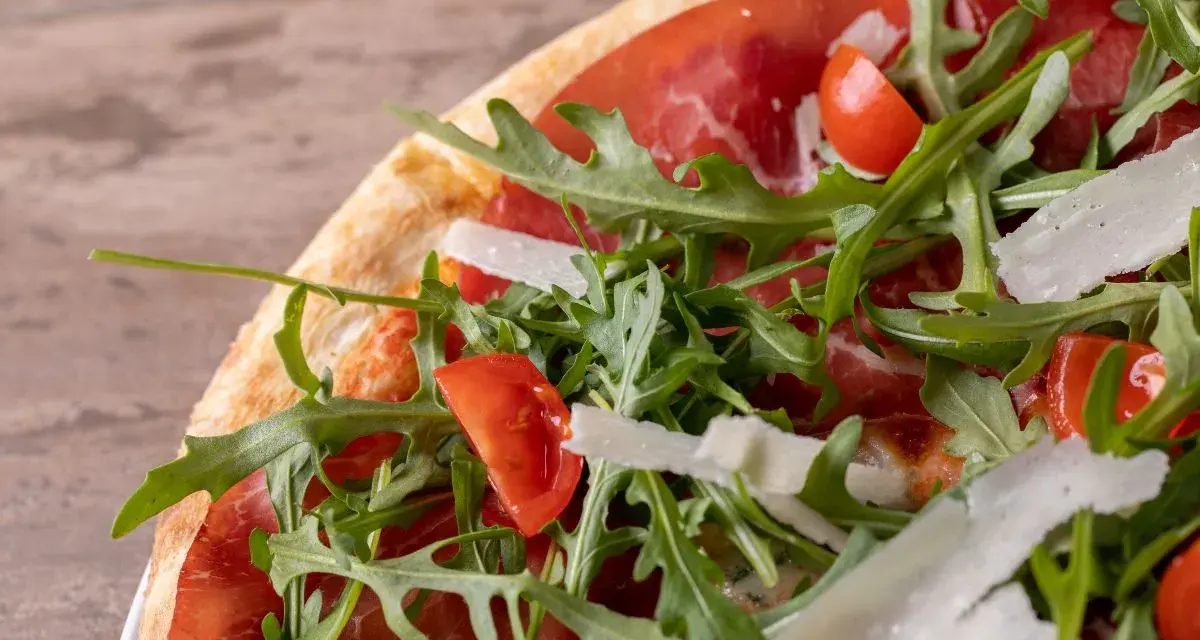 Pizza bresaola rucola e grana: un tripudio di sapori con bresaola, pomodorini, rucola fresca e scaglie di grana.