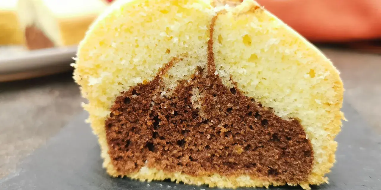 Fetta di ciambella bicolore, chiara e al cacao, soffice e gustosa, perfetta come ciambella per celiaci.
