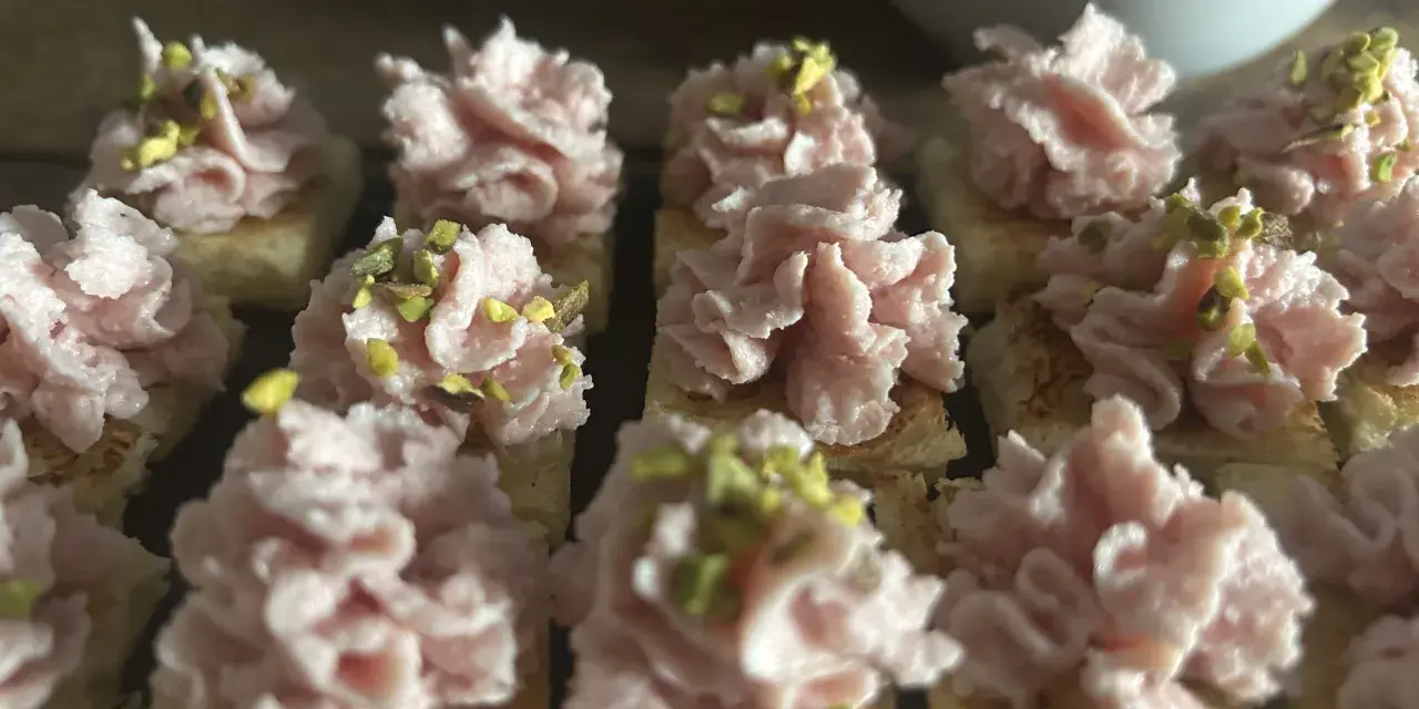Deliziosi crostini con mortadella, stracciatella e pistacchi, pronti per un aperitivo gustoso.