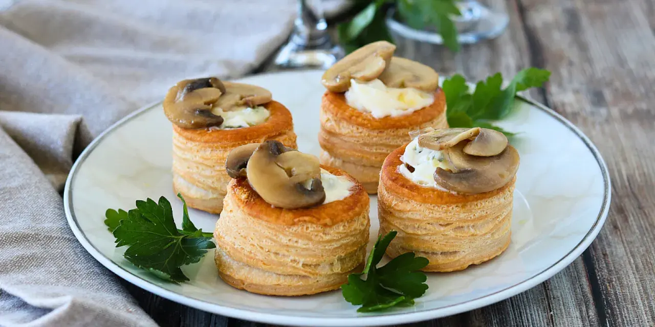 Quattro vol au vent funghi e formaggio, un antipasto sfizioso e gustoso, guarniti con prezzemolo fresco.