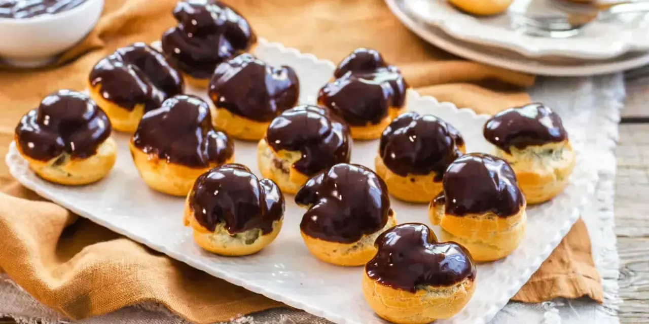 Bignè al cioccolato ricetta: deliziosi bignè ripieni e glassati al cioccolato fondente, pronti per essere gustati.
