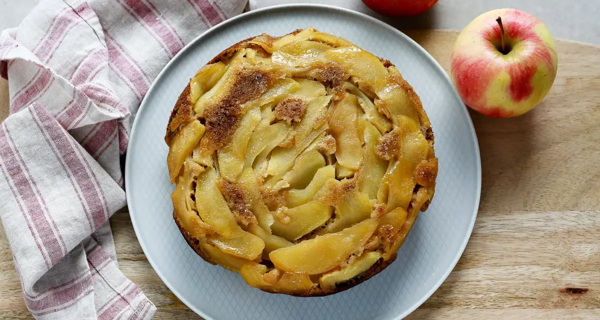 Deliziosa torta rovesciata di mele e noci, con mele caramellate disposte a spirale e una spolverata di zucchero di canna.