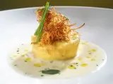 Flan di porri con salsa di acciughe, guarnito con cipolla croccante e erbe aromatiche. Un piatto raffinato che celebra i sapori del mare e della terra.
