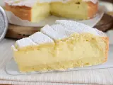 Fetta di crostata con abbondante crema allo yogurt, cosparsa di zucchero a velo.