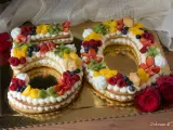 Torta 50 anni con panna, frutta fresca e biscotti a forma di numero. Un dolce colorato e delizioso per festeggiare un traguardo importante.