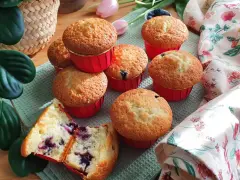 Morbidi muffin ai mirtilli, uno tagliato a metà rivela il suo interno succoso. Perfetti per una colazione o merenda golosa.