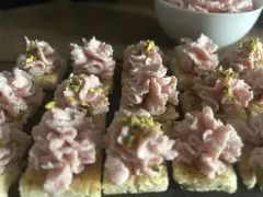 Deliziosi crostini con mortadella, stracciatella e pistacchi, pronti per un aperitivo gustoso.