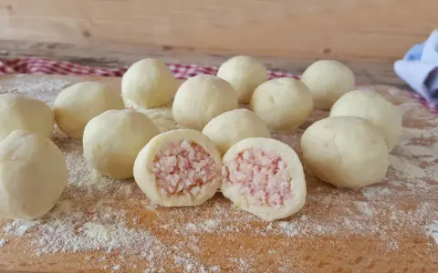 Sfere di gnocco di patate ripieno, pronte per essere cucinate. Una delizia fatta in casa.